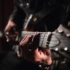 man playing guitar in close up photography