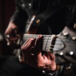 man playing guitar in close up photography